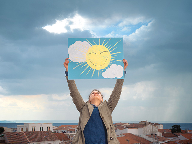 Man on roof with sunshine drawing